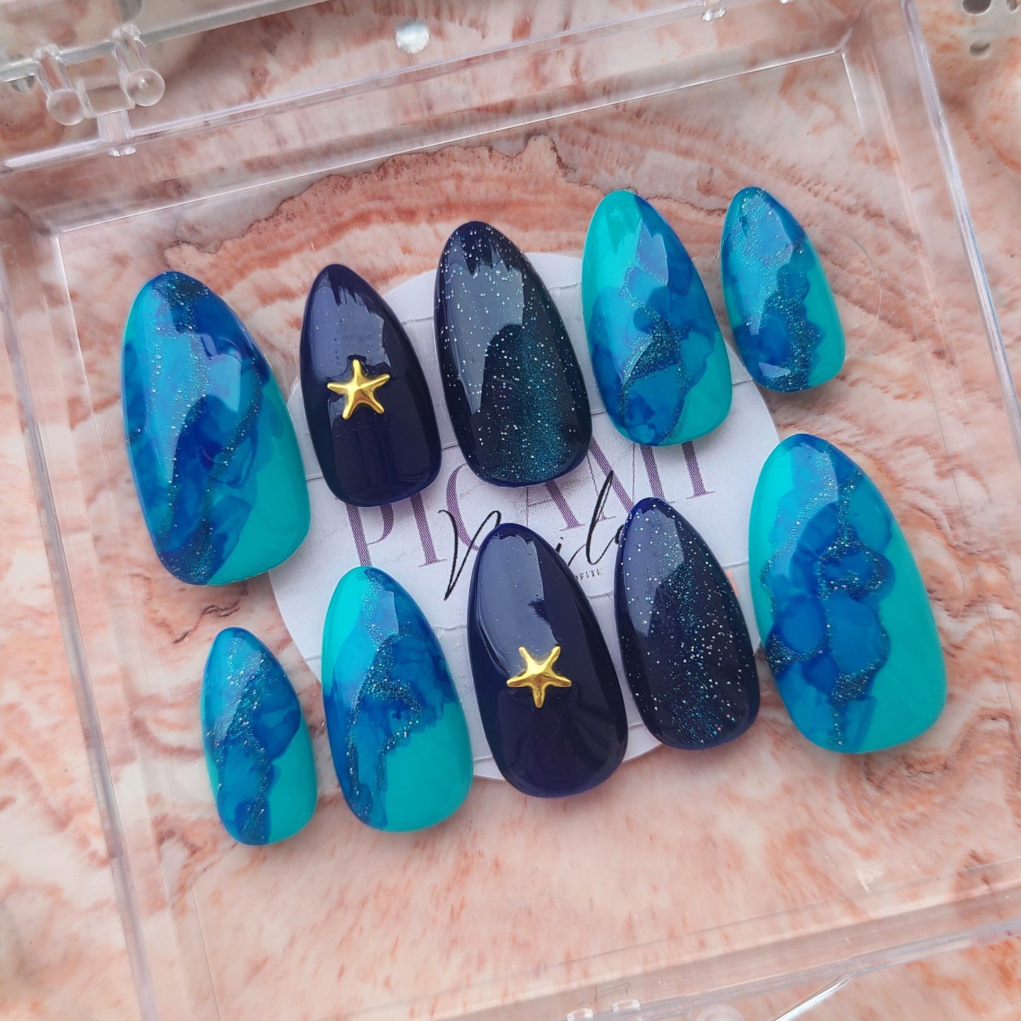 Des tons bleus frais, un effet vague élégant et des strass étoilés pour un look estival irrésistible. Parfait pour des vibes vacances ! 🌊💙